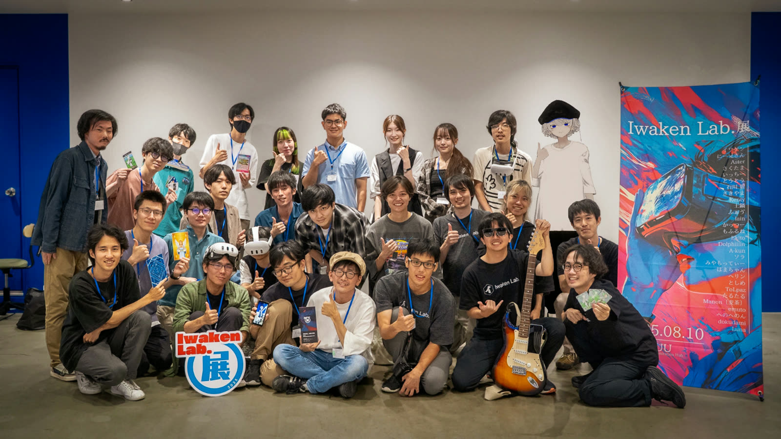 開発合宿 2025 で「Iwaken Lab. 展」のバナーを囲んで集まったメンバーの集合写真
